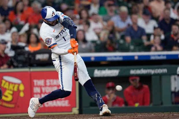 The Houston Astros’ Carlos Correa hits an RBI single during...