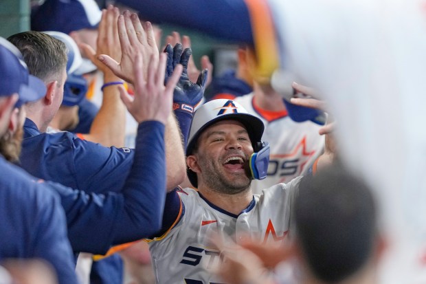 The Houston Astros’ Jose Altuve celebrates in the dugout after...