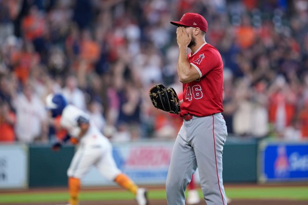 Angels relief pitcher Brock Burke wipes his face after giving...