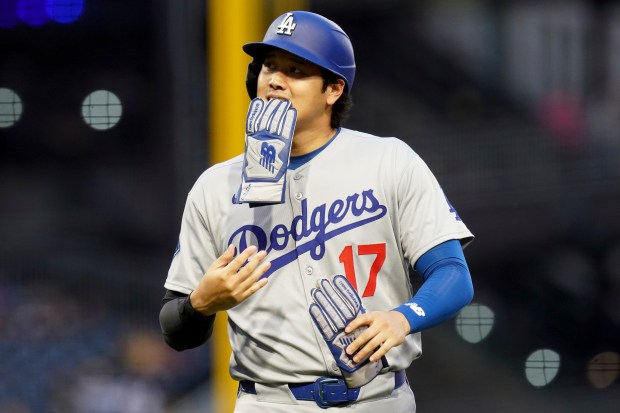 Dodgers star Shohei Ohtani walks to the dugout after Mookie...