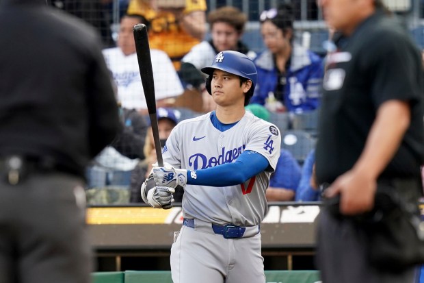 Dodgers star Shohei Ohtani warms up before a baseball game...