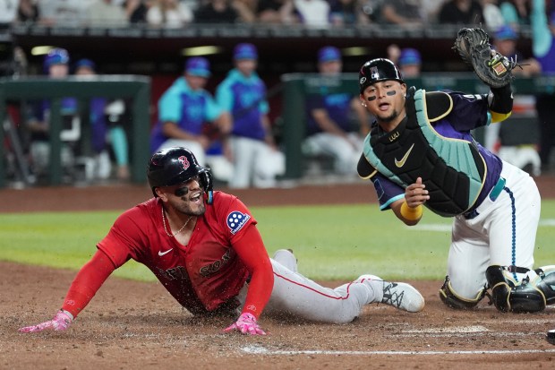 Boston Red Sox's Carlos Narváez, left, is tagged out by Arizona Diamondbacks catcher Gabriel Moreno at home plate during the third inning of a baseball game Friday, Sept. 5, 2025, in Phoenix. (AP Photo/Ross D. Franklin)