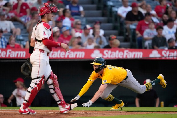 Athletics’ Jacob Wilson, right, scores on a double by Tyler...