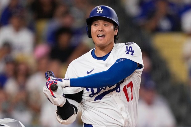 Dodgers star Shohei Ohtani yells as he hits a foul...