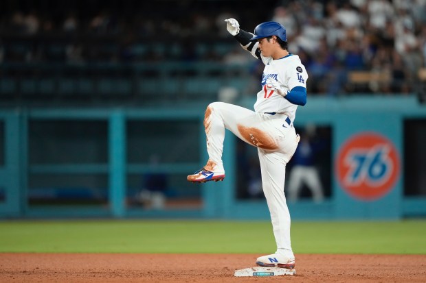 Dodgers star Shohei Ohtani gestures to his dugout from second...