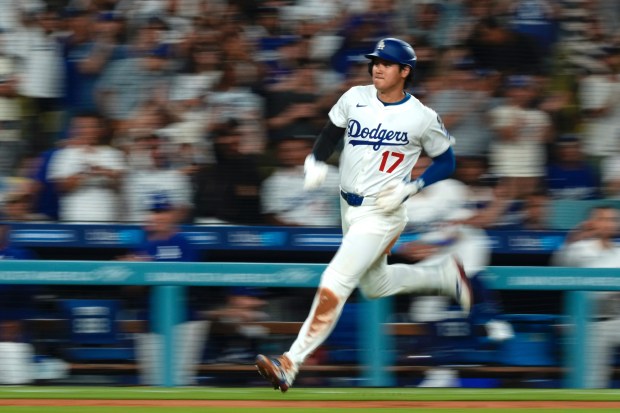 Dodgers star Shohei Ohtani heads home to score on a...