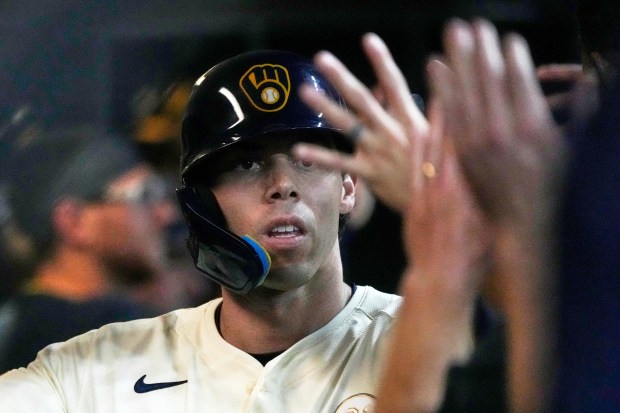 The Milwaukee Brewers’ Christian Yelich is congratulated after hitting a...