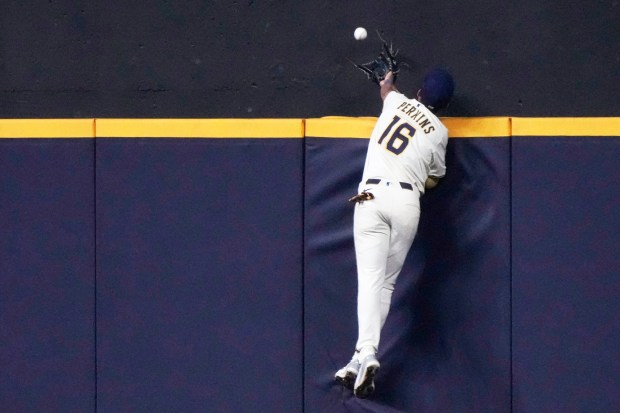 Milwaukee Brewers outfielder Blake Perkins leaps but can’t catch a...