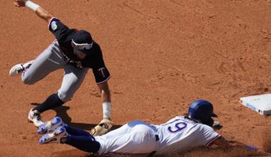 Minnesota Twins second baseman Kody Clemens, top, tags out Texas Rangers' Alejandro Osuna trying to steal the bag during the fifth inning of a baseball game Thursday, Sept. 25, 2025, in Arlington. (AP Photo/Julio Cortez)