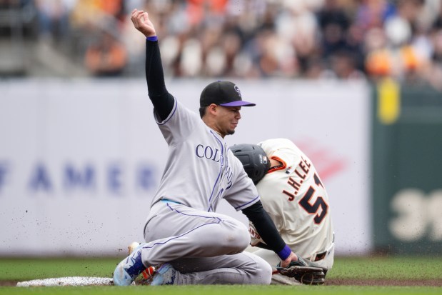 Colorado Rockies shortstop Ezequiel Tovar, left, puts out San Francisco Giants' Jung Hoo Lee (51) during the second inning of a baseball game Sunday, Sept. 28, 2025, in San Francisco. (AP Photo/Thien-An Truong)