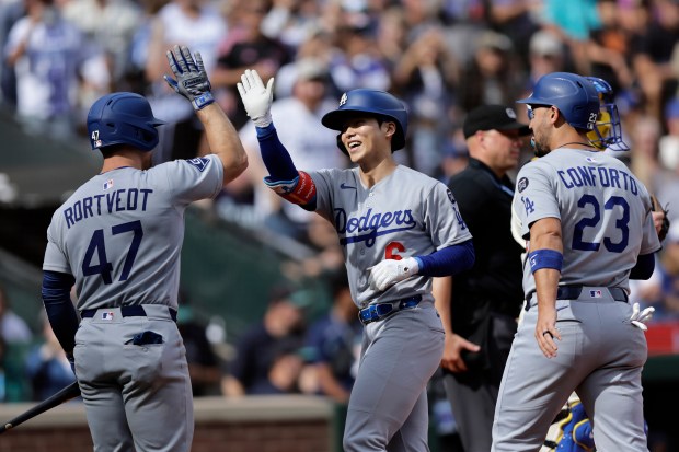 Dodgers’ Hyeseong Kim, center, is greeted by Ben Rortvedt, left,...