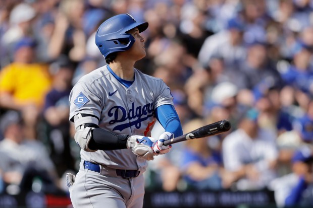Dodgers’ Shohei Ohtani watches his solo home run off Seattle...