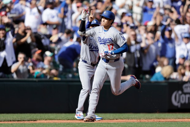 Dodgers’ Shohei Ohtani rounds the bases on his solo home...