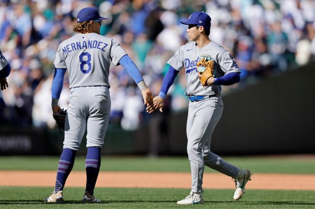 Dodgers’ Enrique Hernándezi, left, greets Hyeseong Kim, right, after a...