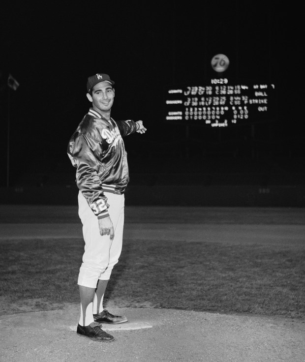 Dodgers pitcher Sandy Koufax poses on the mound with the...