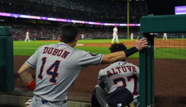 Houston Astros' Mauricio Dubon (14) and Jose Altuve (27) watch from the dugout during the third inning of a baseball game against the Los Angeles Angels Saturday, Sept. 27, 2025, in Anaheim, Calif. (AP Photo/Jae C. Hong)