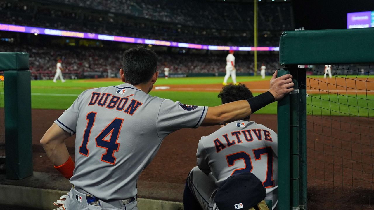 Houston Astros' Mauricio Dubon (14) and Jose Altuve (27) watch from the dugout during the third inning of a baseball game against the Los Angeles Angels Saturday, Sept. 27, 2025, in Anaheim, Calif. (AP Photo/Jae C. Hong)