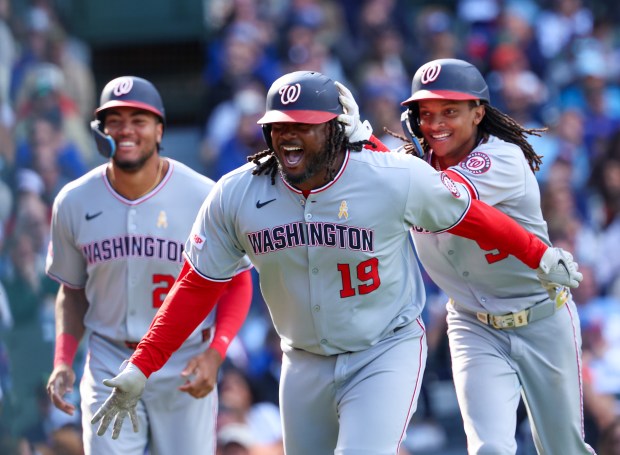 Washington Nationals pinch hitter Josh Bell (19) celebrates with teammates James Wood (29), left, and CJ Abrams (5) after hitting a three-run home run in the top of the ninth inning offChicago Cubs pitcher Daniel Palencia (48) at Wrigley Field on Sept. 7, 2025, in Chicago. (Stacey Wescott/Chicago Tribune)