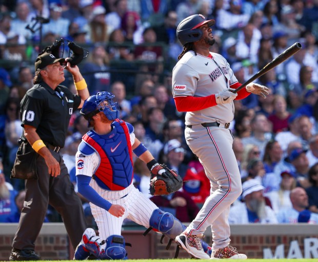 Home plate umpire Phil Cuzzi, Chicago Cubs catcher Carson Kelly (15), and Washington Nationalspinch hitter Josh Bell (19) watch as Bell hits a three-run home run to put his team up 5-3 in the top of the ninth inning at Wrigley Field on Sept. 7, 2025, in Chicago. (Stacey Wescott/Chicago Tribune)