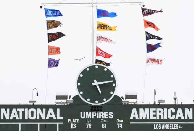 National League standings banners flap in the wind above the scoreboard before a Cubs-Cardinals game at Wrigley Field on July 6, 2025, in Chicago. (John J. Kim/Chicago Tribune)