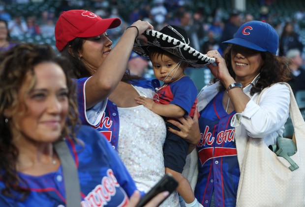 Samantha Jankusky adjusts a sombrero worn by her 9-month-old son, Quinn, on Hispanic and Latino Heritage Night at Wrigley Field before a Cubs-Mets game on Sept. 25, 2025, in Chicago. (John J. Kim/Chicago Tribune)