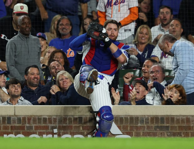 Cubs catcher Carson Kelly bounces off the protective netting after catching a foul ball from Mets first baseman Pete Alonso in the third inning Sept. 25, 2025, at Wrigley Field. (John J. Kim/Chicago Tribune)