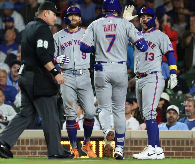 Mets left fielder Brandon Nimmo (9) and catcher Luis Torrens (13) wait for third baseman Brett Baty to come home after hitting a three-run home run against the Cubs in the fourth inning at Wrigley Field on Sept. 25, 2025, in Chicago. (John J. Kim/Chicago Tribune)