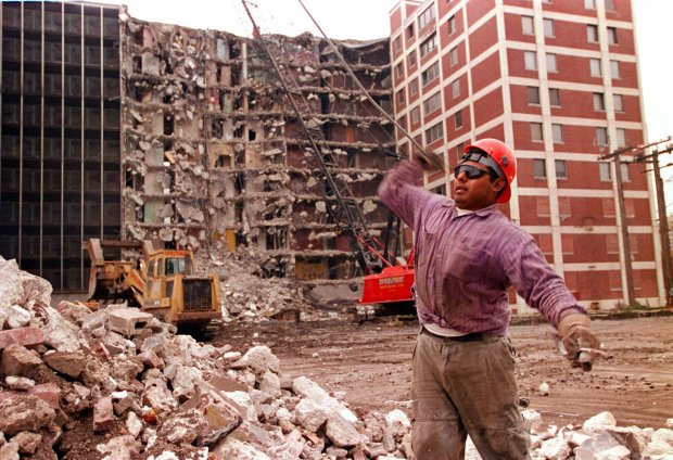 Worker Greg Hernandez separates materials from a pile of rubble during the teardown of the Cabrini-Green development at 1157 and 1159 Cleveland Ave. on Oct. 30, 1995, in Chicago. (José Moré/Chicago Tribune)