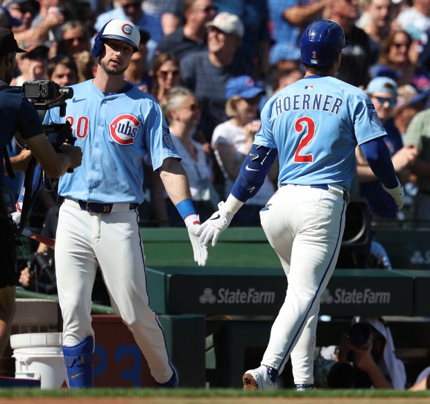 Chicago Cubs second baseman Nico Hoerner (2) is congratulated by teammate Kyle Tucker after hitting a solo home run in the first inning against the St. Louis Cardinals at Wrigley Field in Chicago on Sept. 26, 2025. (Chris Sweda/Chicago Tribune)