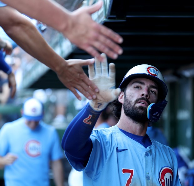 Chicago Cubs shortstop Dansby Swanson is congratulated in the dugout after scoring on a triple by Matt Shaw in the seventh inning of a game against the St. Louis Cardinals at Wrigley Field in Chicago on Sept. 26, 2025. (Chris Sweda/Chicago Tribune)