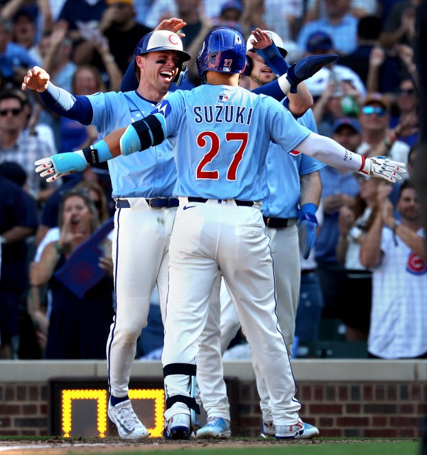 Chicago Cubs right fielder Seiya Suzuki (27) is congratulated by his teammates, including Nico Hoerner, after Suzuki hit a grand slam in the seventh inning of a game against the St. Louis Cardinals at Wrigley Field in Chicago on Sept. 26, 2025. (Chris Sweda/Chicago Tribune)