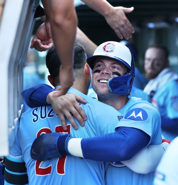 Chicago Cubs second baseman Nico Hoerner gives out a big hug to teammate Seiya Suzuki (27) after Suzuki hit a grand slam in the seventh inning of a game against the St. Louis Cardinals at Wrigley Field in Chicago on Sept. 26, 2025. (Chris Sweda/Chicago Tribune)