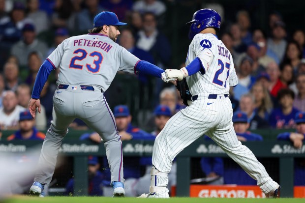 New York Mets pitcher David Peterson (23) tags out Chicago Cubs outfielder Seiya Suzuki (27) during the first inning at Wrigley Field Tuesday Sept. 23, 2025, in Chicago. (Armando L. Sanchez/Chicago Tribune)
