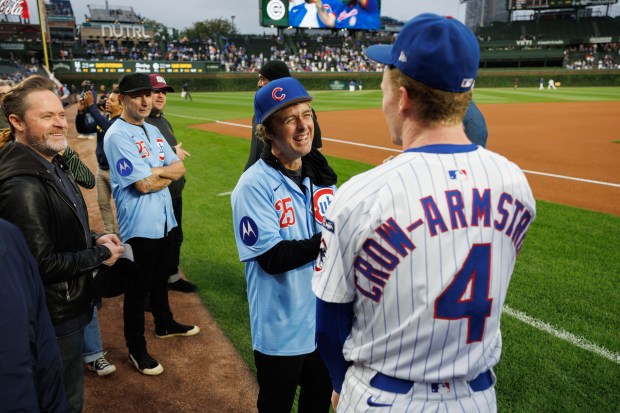Green Day lead singer Billie Joe Armstrong laughs while talking with Chicago Cubs outfielder Pete Crow-Armstrong (4) before the Cubs play the New York Mets at Wrigley Field Tuesday Sept. 23, 2025, in Chicago. (Armando L. Sanchez/Chicago Tribune)