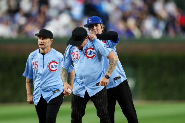 Members of Green Day throw out the first pitch before the Chicago Cubs play the New York Mets at Wrigley Field on Tuesday, Sept. 23, 2025, in Chicago. (Armando L. Sanchez/Chicago Tribune)