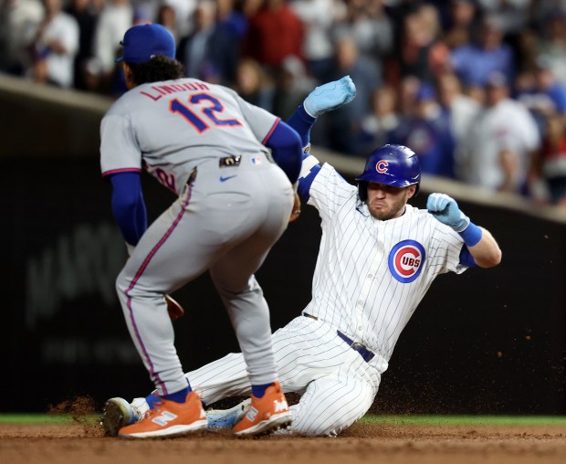 Chicago Cubs left fielder Ian Happ slides into second base with a two-run double in the third inning of a game against the New York Mets at Wrigley Field in Chicago on Sept. 24, 2025. (Chris Sweda/Chicago Tribune)