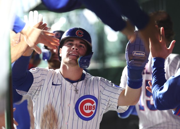 Chicago Cubs third baseman Matt Shaw is congratulated by his teammates in the dugout after scoring on a two-run double by Ian Happ in the third inning of a game against the New York Mets at Wrigley Field in Chicago on Sept. 24, 2025. (Chris Sweda/Chicago Tribune)