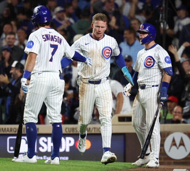 Chicago Cubs center fielder Pete Crow-Armstrong (center) is congratulated by his teammates Dansby Swanson (7) and Matt Shaw (right) after Crow-Armstrong scored on a wild pitch in the fifth inning of a game against the New York Mets at Wrigley Field in Chicago on Sept. 24, 2025. (Chris Sweda/Chicago Tribune)