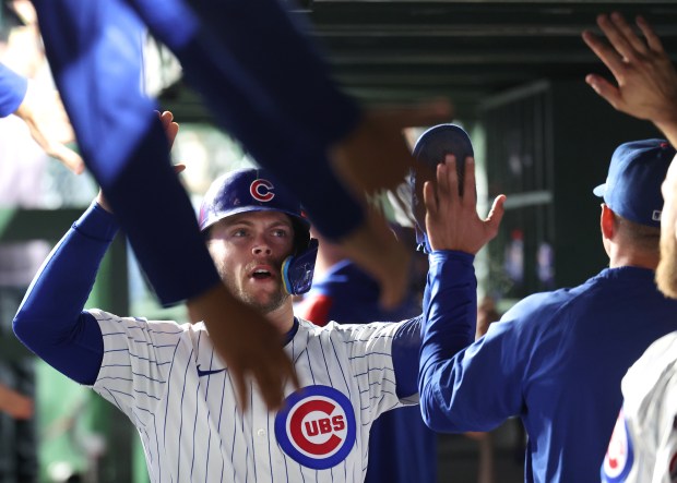 Chicago Cubs second baseman Nico Hoerner is congratulated by his teammates in the dugout after scoring on a single by designated hitter Moisés Ballesteros in the third inning of a game against the New York Mets at Wrigley Field in Chicago on Sept. 24, 2025. (Chris Sweda/Chicago Tribune)