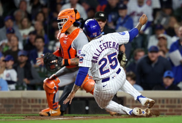 Chicago Cubs designated hitter Moisés Ballesteros (25) slides in safely at home plate to score on a sacrifice fly by teammate Pete Crow-Armstrong in the third inning of a game against the New York Mets at Wrigley Field in Chicago on Sept. 24, 2025. (Chris Sweda/Chicago Tribune)