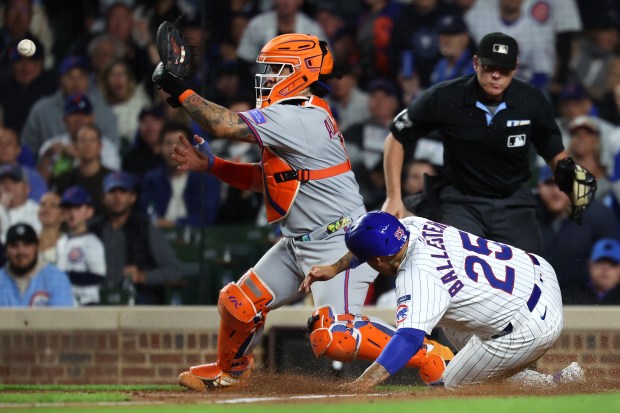 Chicago Cubs designated hitter Moisés Ballesteros (25) slides in safely at home plate to score on a sacrifice fly by teammate Pete Crow-Armstrong in the third inning of a game against the New York Mets at Wrigley Field in Chicago on Sept. 24, 2025. (Chris Sweda/Chicago Tribune)