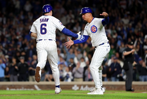 Chicago Cubs third baseman Matt Shaw (6) is congratulated by third base coach Quintin Berry as Shaw rounds the bases after hitting a solo home run in the fourth inning of a game against the New York Mets at Wrigley Field in Chicago on Sept. 24, 2025. (Chris Sweda/Chicago Tribune)