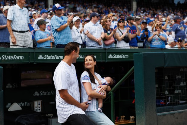 Former Cubs first baseman Anthony Rizzo and his wife Emily stand in the dugout with their child before the Cubs play the Tampa Bay Rays at Wrigley Field after the Cubs announced he would retire and become an ambassador for the team he helped lead to a World Series in 2016 Saturday Sept. 13, 2025, in Chicago. (Armando L. Sanchez/Chicago Tribune)