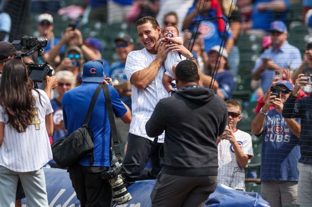 Former Cubs first baseman Anthony Rizzo holds up his child before throwing a ceremonial first pitch before a game against the Rays on Saturday, Sept. 13, 2025, at Wrigley Field. (Armando L. Sanchez/Chicago Tribune)