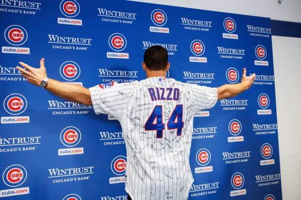 Former Cubs first baseman Anthony Rizzo puts on a jersey while speaking with members of the press before the Cubs play the Tampa Bay Rays at Wrigley Field after the Cubs announced he would retire and become an ambassador for the team he helped lead to a World Series in 2016 Saturday Sept. 13, 2025, in Chicago. (Armando L. Sanchez/Chicago Tribune)