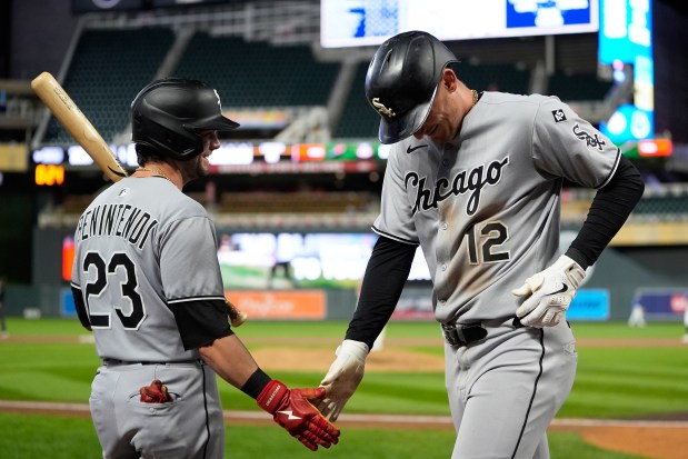 Chicago White Sox's Colson Montgomery (12) celebrates with Andrew Benintendi (23) after hitting a 2-run home run during the ninth inning of a baseball game against the Minnesota Twins Thursday, Sept. 4, 2025, in Minneapolis. (AP Photo/Abbie Parr)