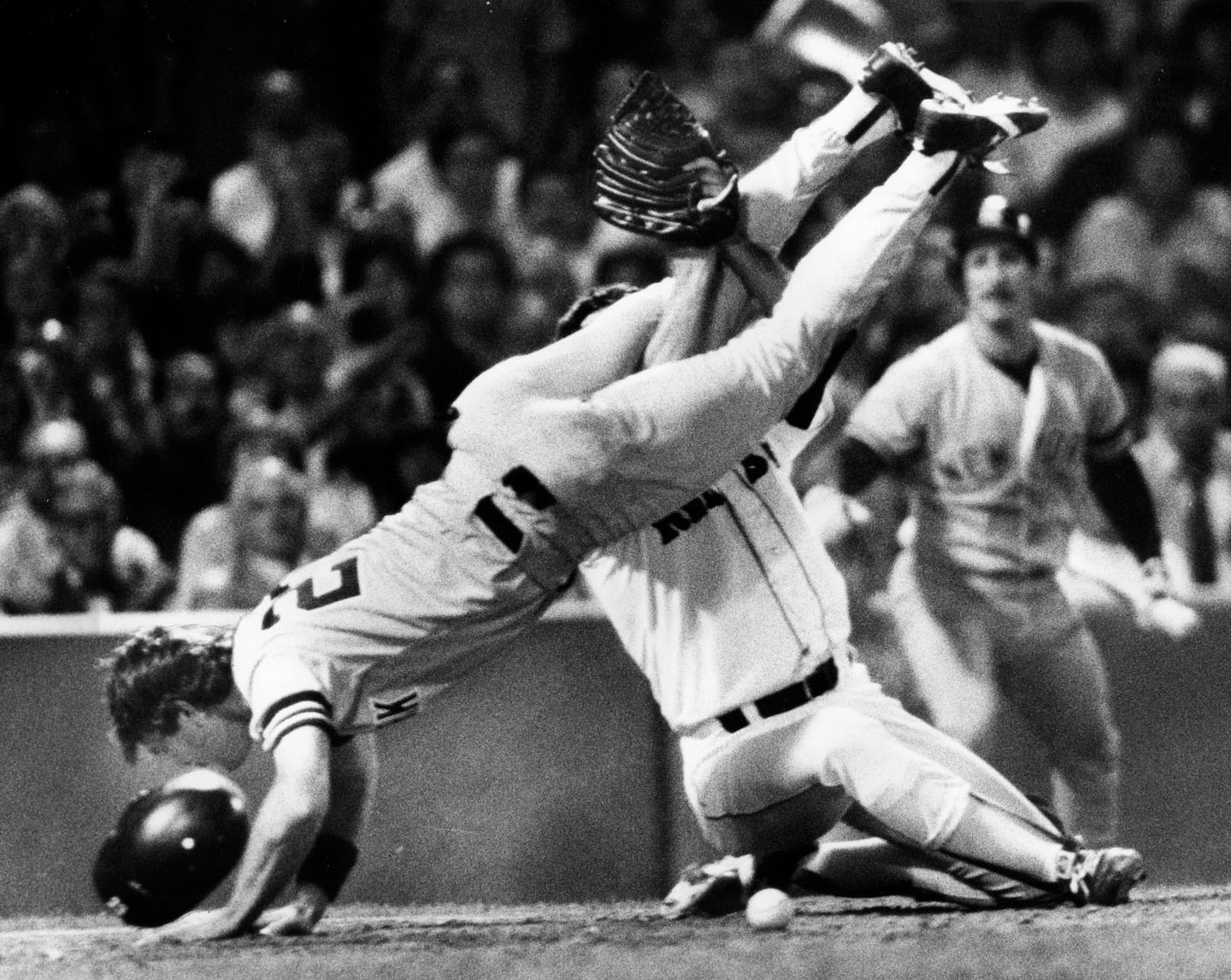 Yankees first baseman Don Mattingly crashed into home plate to score a run during a 1986 game, bowling over Sox pitcher Rob Woodward in the process.