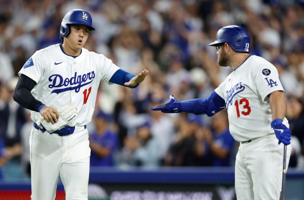 Dodgers star Shohei Ohtani, left, celebrates with teammate Max Muncy...