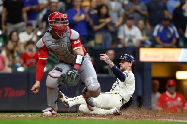 The Milwaukee Brewers’ Brice Turang slides safely home to score...