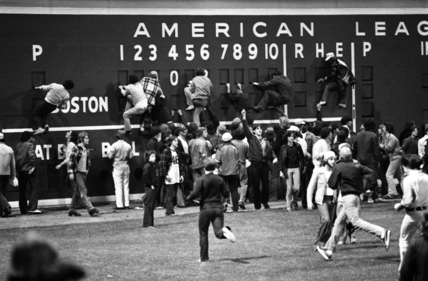Spectators streamed onto the field at Fenway Park and began to climb the Green Monster after the Reds won Game 7.